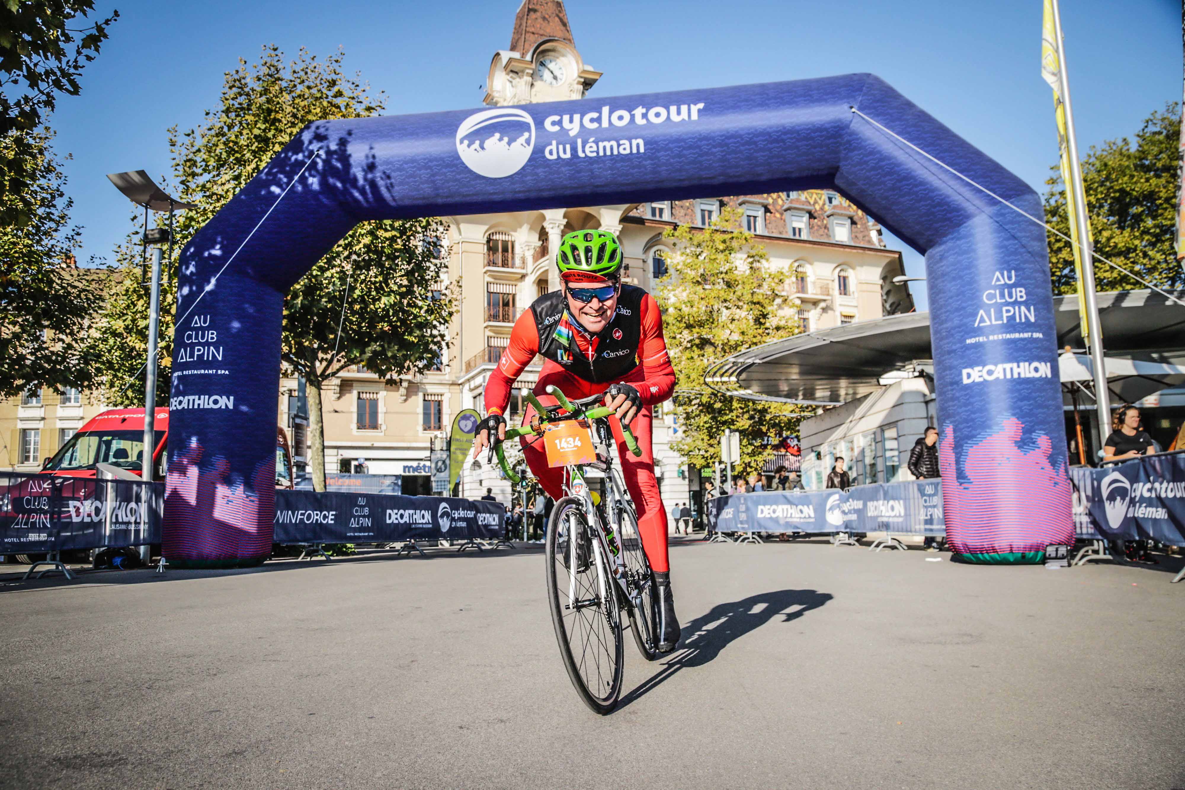 cyclist smiling at camera across finish line